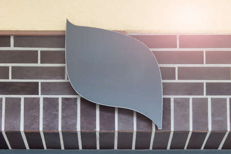 Hanging curved shop banner on brick wall.の写真素材