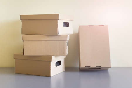 Many stacked brown carton boxes laying on table.