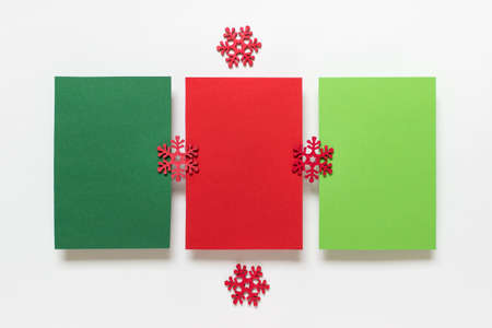 Christmas, New Year mockup template with three green and red cards and red wooden snowflakes on white background.の写真素材