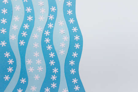 Abstract Christmas background with wavy blue paper layers, white snowflakes and copy blank space.の写真素材