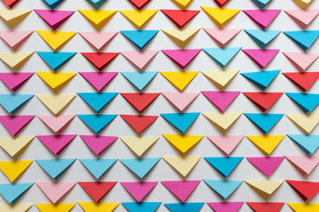 Abstract background with arranged in rows colorful folded triangles on white background.の写真素材