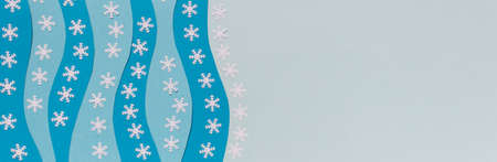 Wide long banner with Christmas colored paper layers with decorative white snowflakes. Image with copy blank space.の写真素材
