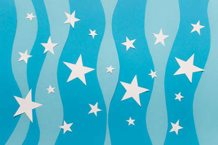 Simple paper background with white paper stars on blue background.の写真素材