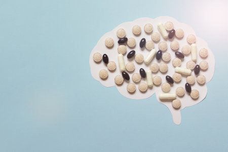 Illustration with paper brain cutout and medical vitamin pills. Image with copy blank space.の写真素材