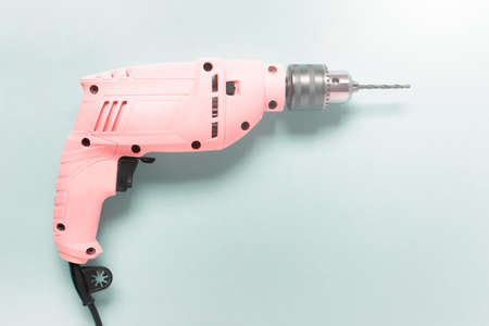 Home renovation pink drill on blue background. Image with copy blank space.の写真素材