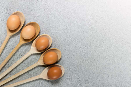 Simple easter composition with wooden spoons and five brown chicken eggs on gray background. Image with copy blank space.の写真素材