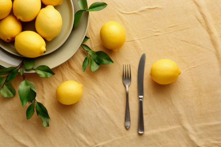A vibrant composition featuring fresh lemons, colorful plates, and yellow cloth, accompanied by forks, knives, and spoons, evoking the refreshing and appetizing essence of summer refreshments. Generative AIの素材