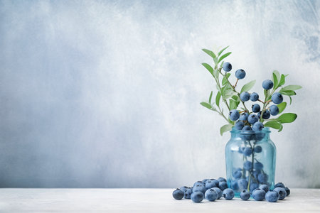 Delicate composition with blueberries branch in blue glass vase and blueberries on the right side of image, image with copy blank space, Generative AIの素材