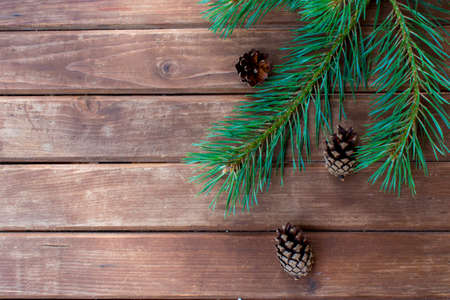 Christmas tree branch on a wooden table or board for background. New year theme. Space for text.