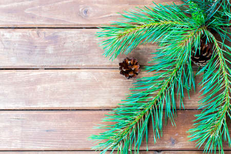 Christmas tree branch on a wooden table or board for background. New year theme. Space for text.