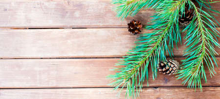 Christmas tree branch on a wooden table or board for background. New year theme. Space for text.の写真素材