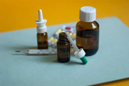 Medicines for colds, flu, viral diseases. Cough and cold remedies. Glass jars with syrup, colored tablets.の写真素材