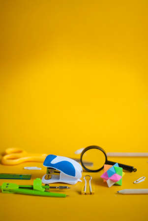 School office supplies. Back to school concept. Stationery on a bright yellow background with place for text. Banner or poster for a stationery store.の写真素材