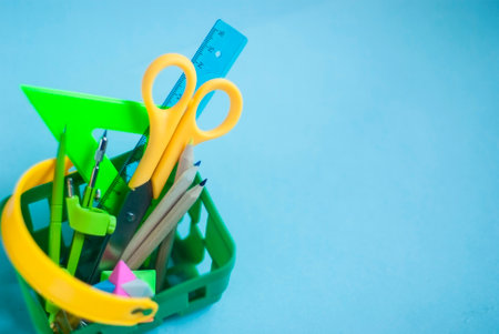 Back to school. A basket with stationery. Bright green shopping cart from the supermarket.の写真素材