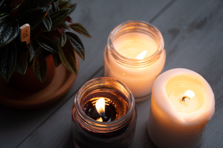 Candles. Home interior decoration. Romantic candles. White and black wax. In glass jars. Romantic atmosphere at home.の写真素材
