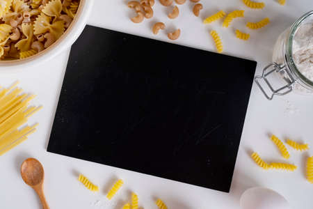 Assorted Italian pasta. On a white background. View from above. Pasta on a plate. Flour, eggs and...