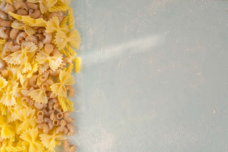 Pasta frame with different types of italian pasta. On a blue background.の写真素材