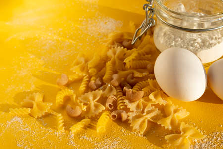 Assorted types of pasta on yellow background. Various forms of pasta. Close upの写真素材