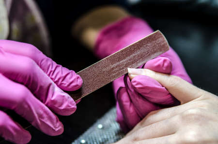 Manicurist file nails nail file and adjusts the shape of the nail.の写真素材