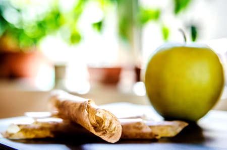 Apple pastille wrapped in straws lying on a table on the background of an apple.の写真素材