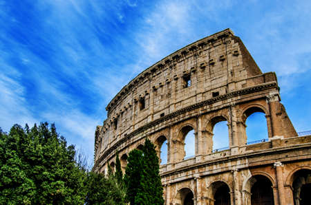 The ancient arches of the colosseum against the blue sky with white traces from the floating clouds. Rome. Italyの写真素材
