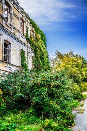 A ruined building shrouded in shrubs and trees in the Botanical Garden. Kyiv. Ukraineの写真素材