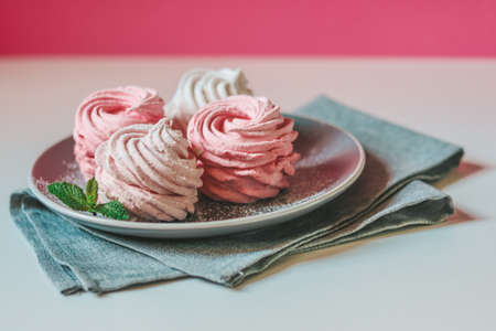 Homemade pink berry zephyr on a vivid pink background with a grey napkinの写真素材