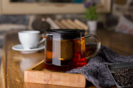 Classic hot black tea in a glass teapot in cafe. Health drink. Enjoying hot beverage in cold winter evening. Selective focusの写真素材