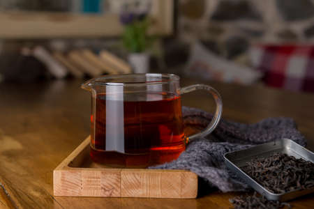 Classic hot black tea in a glass teapot in cafe. Health drink. Enjoying hot beverage in cold winter evening. Selective focusの写真素材