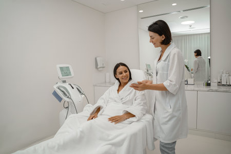 Happy cheerful Caucasian woman spending time in cosmetologist cabinet while choosing care productの写真素材