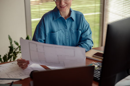 Woman engineer construction is developing construction project documentation sitting at home officeの写真素材