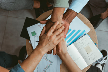 Top view of group multi ethnic coworkers stacked hands together as concept of corporate unity