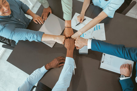 Top view of group multi ethnic coworkers stacked hands together as concept of corporate unity