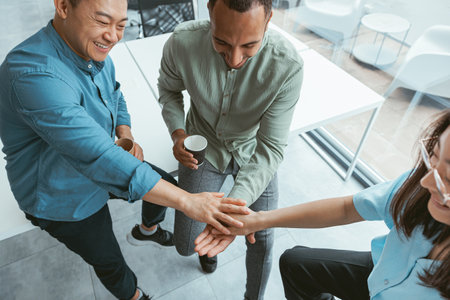 Top view of group multi ethnic coworkers stacked hands together as concept of corporate unity