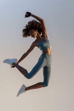 Active sporty woman in sportswear jumping on studio background. Sport and healthy lifestyle