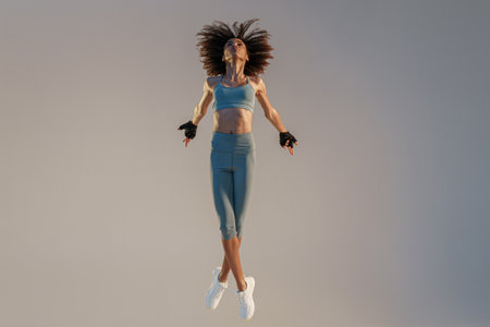 Active sporty woman in sportswear jumping on studio background. Sport and healthy lifestyle