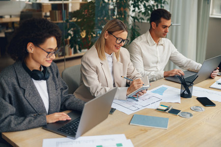 Business team is analysing new financial project while working together on office deskの写真素材