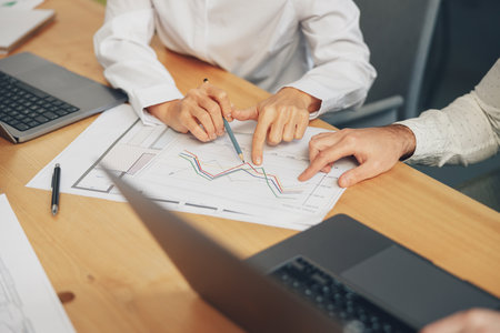 Close up of business team is analysing new financial project while working together on office deskの写真素材