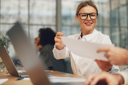 Close up of businesspeople working together with financial documents in officeの写真素材