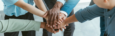 Top view of group multi ethnic coworkers stacked hands together as concept of corporate unity
