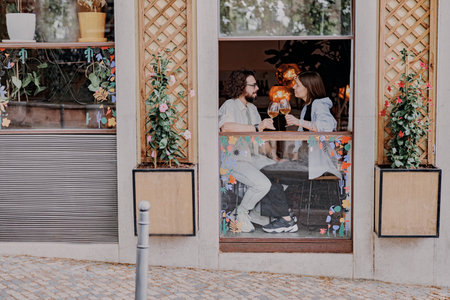 Smiling couple drinking wine at restaurant and talking. Love, dating and holidays concept