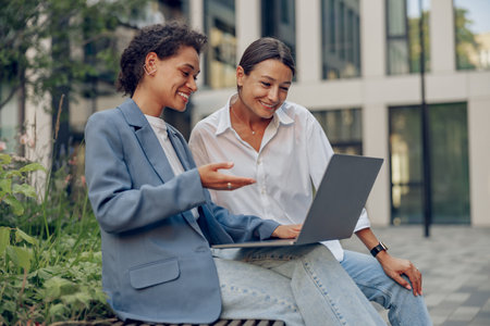 Business coworkers working on project while use laptop sitting in coworking terraceの写真素材