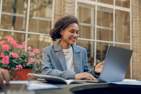 Stylish business woman sitting in modern coworking and working on laptop. High quality photo