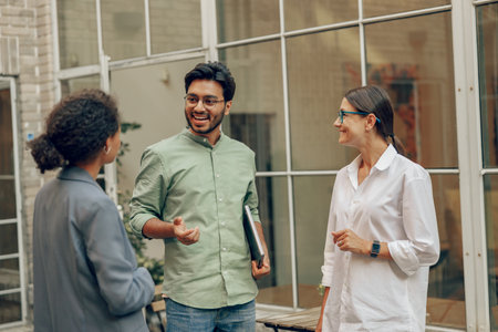 Group of business people talks during break standing on background of modern coworking buildingの写真素材
