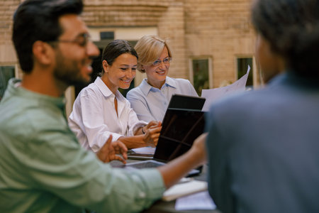 Creative team collaborating on project during meeting in outdoor cafe. Conception of businessの写真素材