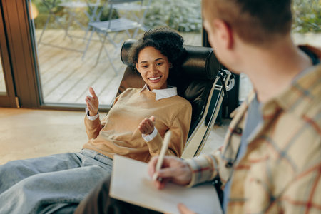 Female patient talks about her problems while lying on couch at psychologist appointmentの写真素材