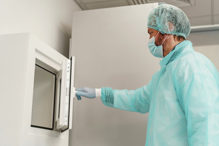 Male scientist in uniform and mask working in medical research laboratory