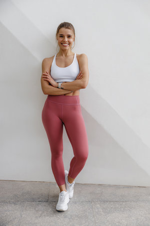 Female athlete in sportswear have a rest after morning jogging outside and looks cameraの写真素材