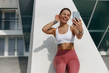 Sporty smiling young woman after running making selfie outdoors. Active life conceptの写真素材