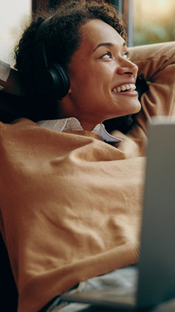 A Joyful Young Woman Happily Enjoying Her Favorite Music While Relaxing Comfortably at Home
